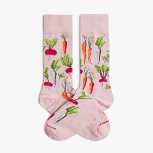 The Root Veg Socks - Rose by Jimmy Lion are light pink and feature a colourful pattern of carrots, radishes, and other root vegetables. They are displayed flat with the toes overlapping. Gate21.ee