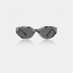 Winnie - Cookie Dough: Cat-eye sunglasses by A. Kjærbede in a grey hue with dark lenses and subtly curved arms, shown on a plain white background. Gate21.ee