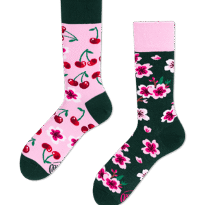 The Cherry Blossom socks set includes one pink sock with red cherries and green accents, and one dark green sock with pink and white flowers—each featuring a lively floral design in unique colours. Gate21.ee