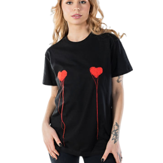 A woman with long, wavy hair models the LUKS - 1 S&uuml;da - T-shirt, a loose black tee with two red heart designs and line details, paired with black trousers&mdash;perfect for exploring a concept store. She poses against a plain white background. Gate21.ee