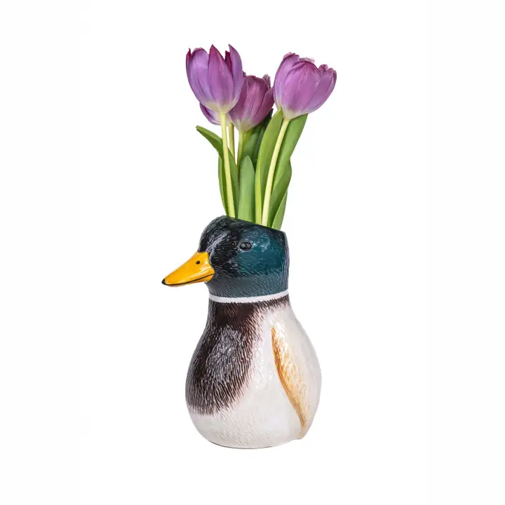 The Duck - Vase, shaped like a duck’s head and upper body, holds several purple tulips with green stems and is displayed against a plain white background. Gate21.ee
