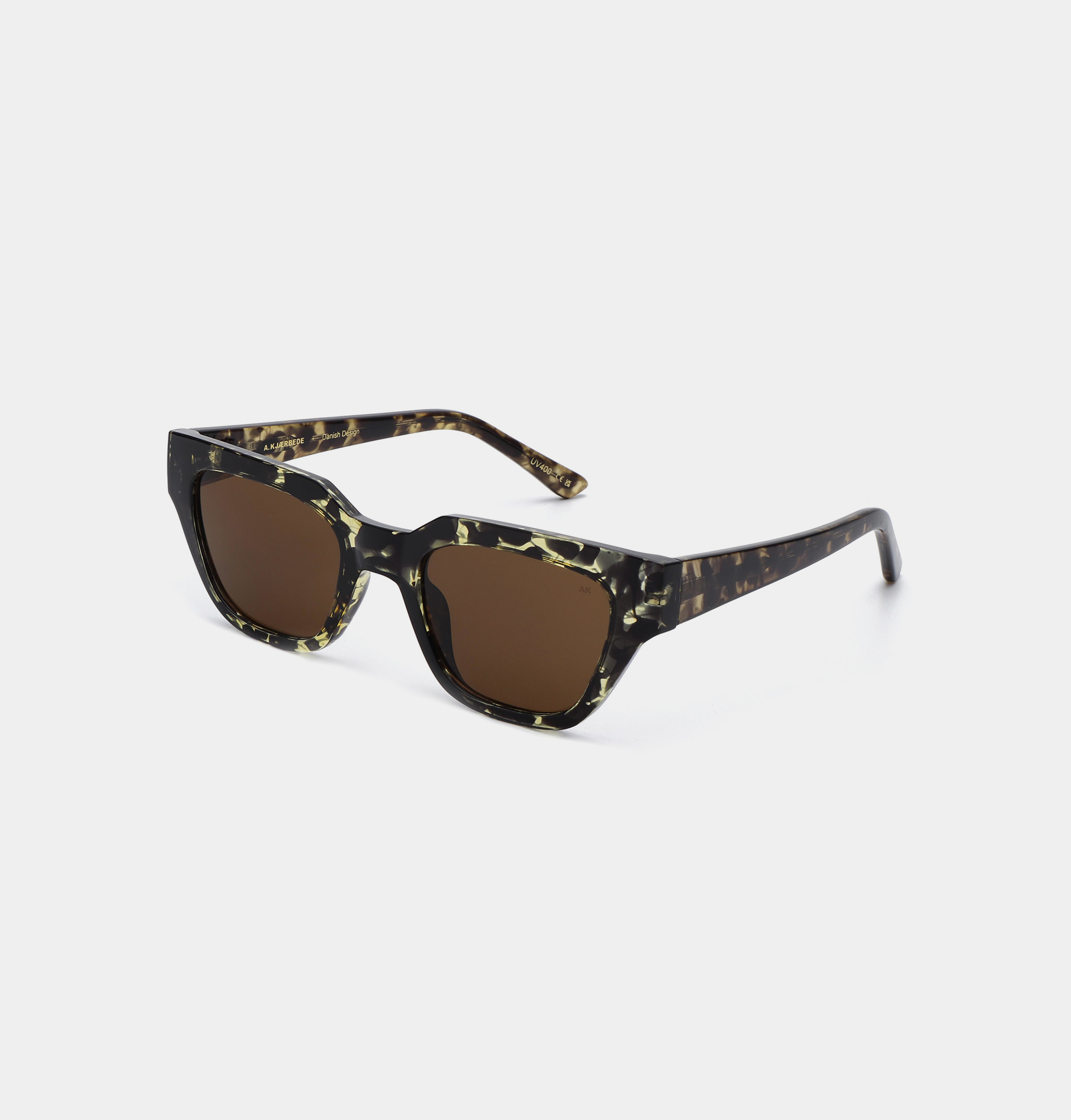A pair of KAWS - Black/Yellow Tortoise square-shaped sunglasses featuring dark brown lenses and a black and yellow tortoiseshell-patterned frame, displayed on a white background. Gate21.ee