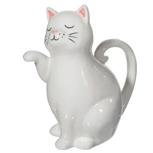A white ceramic watering can shaped like a sitting cat with closed eyes, a raised paw, and a curved tail as the handle. Pink accents detail its nose and ears. Product name: Cat - Watering can. Gate21.ee