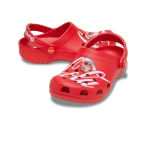 The Crocs Coca-Cola® Classic Clog is a pair of red clogs with the Coca-Cola logo, a themed badge on top, and white writing on the heel strap. One shoe is placed slightly in front of the other. Gate21.ee