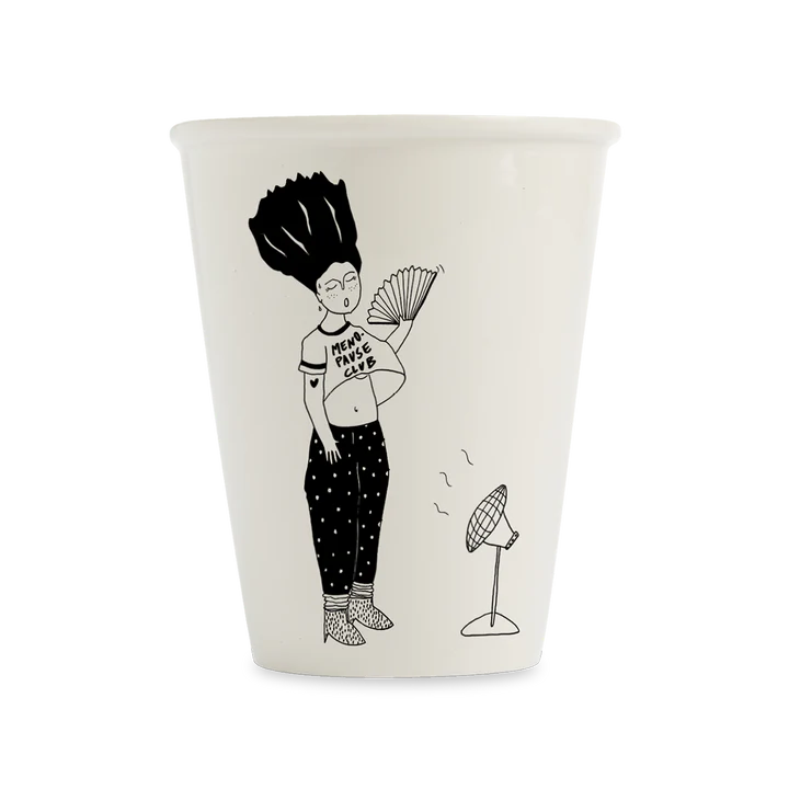The Menopause club cup by Helen B showcases a black line drawing of a glasses-wearing person with big hair standing before a fan, holding open a shirt that reads "Mens Fan Club," and wearing patterned trousers. Gate21.ee