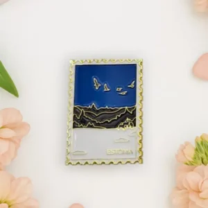 A rectangular magnet designed like a postage stamp features birds flying over a landscape with “Estonia” written at the bottom. Much like the vibrant touches found on a New Rebels small rucksack, this Magnet – talvine mets is surrounded by flowers and heart-shaped objects on a white surface. Gate21.ee