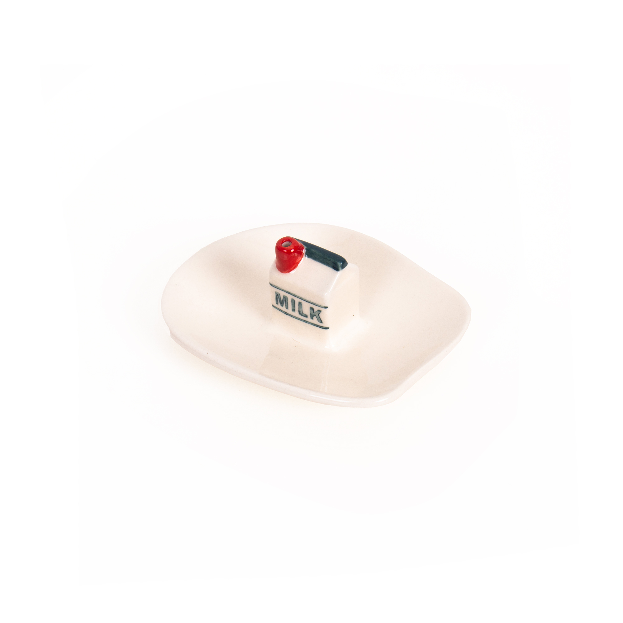 The Incense burner - Milk is a small ceramic dish featuring a miniature milk carton design at its centre, complete with the word “MILK” on the side and a red accent on top. Reminiscent of Helio Ferreti’s modern and colourful incense burners, this piece adds playful charm with its curved, upturned edges. Gate21.ee