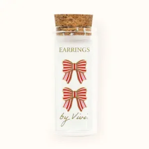 A small clear bottle with a cork stopper contains stylish champagne-shaped earrings. The label reads “Champagne earrings by Vivi,” and the earrings are arranged vertically inside the bottle. Gate21.ee