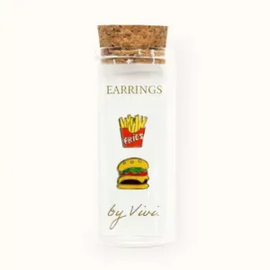 A clear bottle with a cork lid labelled “Champagne earrings by Vivi.” The label is decorated with illustrated images of a burger and chips, giving it a playful flair. Designed to hold special pieces like Vivi’s Champagne earrings, the empty bottle is photographed against a white background. Gate21.ee