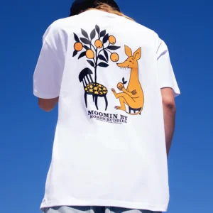 Person wearing a white “Moomin Ts - Sniff - White” T-shirt featuring a graphic of Sniff (the yellow creature), a chair with flowers, and a fruit tree against a blue sky. The shirt reads MOOMIN BY NORDEGBUDDIES. Gate21.ee