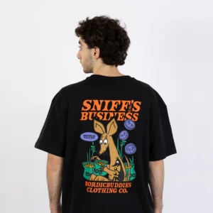 Wearing the “Moomin Ts - Sniff’s Business- Black” T-shirt, a person is seen from behind; the shirt showcases a cartoon kangaroo, playful greenery, and bold text reading SNIFFS BUSINESS and NORDICBUDDIES CLOTHING CO. across the back—capturing the fun style typical of popular Moomin T-shirts. Gate21.ee