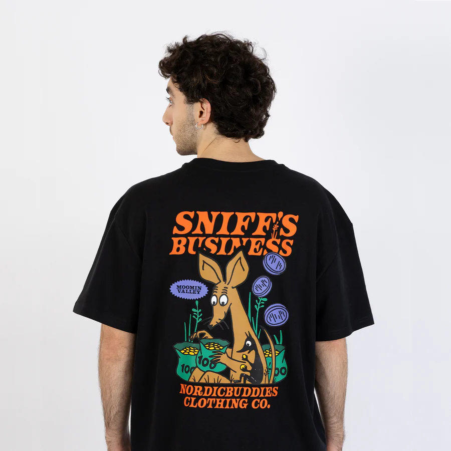 Wearing the “Moomin Ts - Sniff’s Business- Black” T-shirt, a person is seen from behind; the shirt showcases a cartoon kangaroo, playful greenery, and bold text reading SNIFFS BUSINESS and NORDICBUDDIES CLOTHING CO. across the back—capturing the fun style typical of popular Moomin T-shirts. Gate21.ee