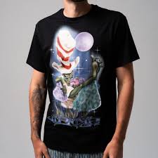 A person wearing a black Big Poe Tee from RIPnDIP, which features a graphic of a green creature in a red and white striped hat holding a smaller figure, set against a background with a purple moon and stars. Gate21.ee