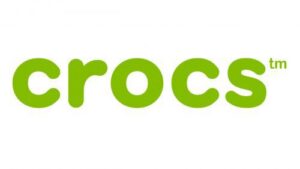 The image shows the Crocs Barbie® Classic Clog logo, with the word "crocs" in bold, lowercase, rounded green letters on a white background. The letters "tm" appear in small green type above the last letter. Gate21.ee