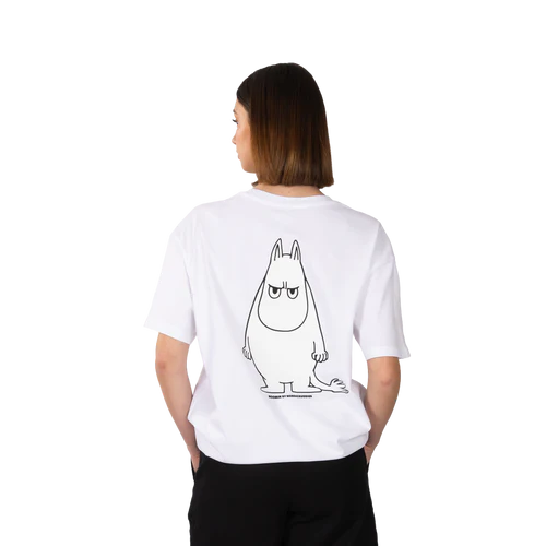 A person with straight, shoulder-length brown hair faces away, wearing the white Moomintroll Temper Heavy Ts, which features a large outlined drawing of a serious Moomin character. The background is plain white. Gate21.ee