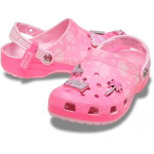 A pair of Crocs Barbie® Classic Clog in bright pink with a semi-transparent finish, decorated with Barbie-themed charms such as a palm tree, a convertible, and the Barbie logo. These clogs feature ventilation holes and a back strap. Gate21.ee