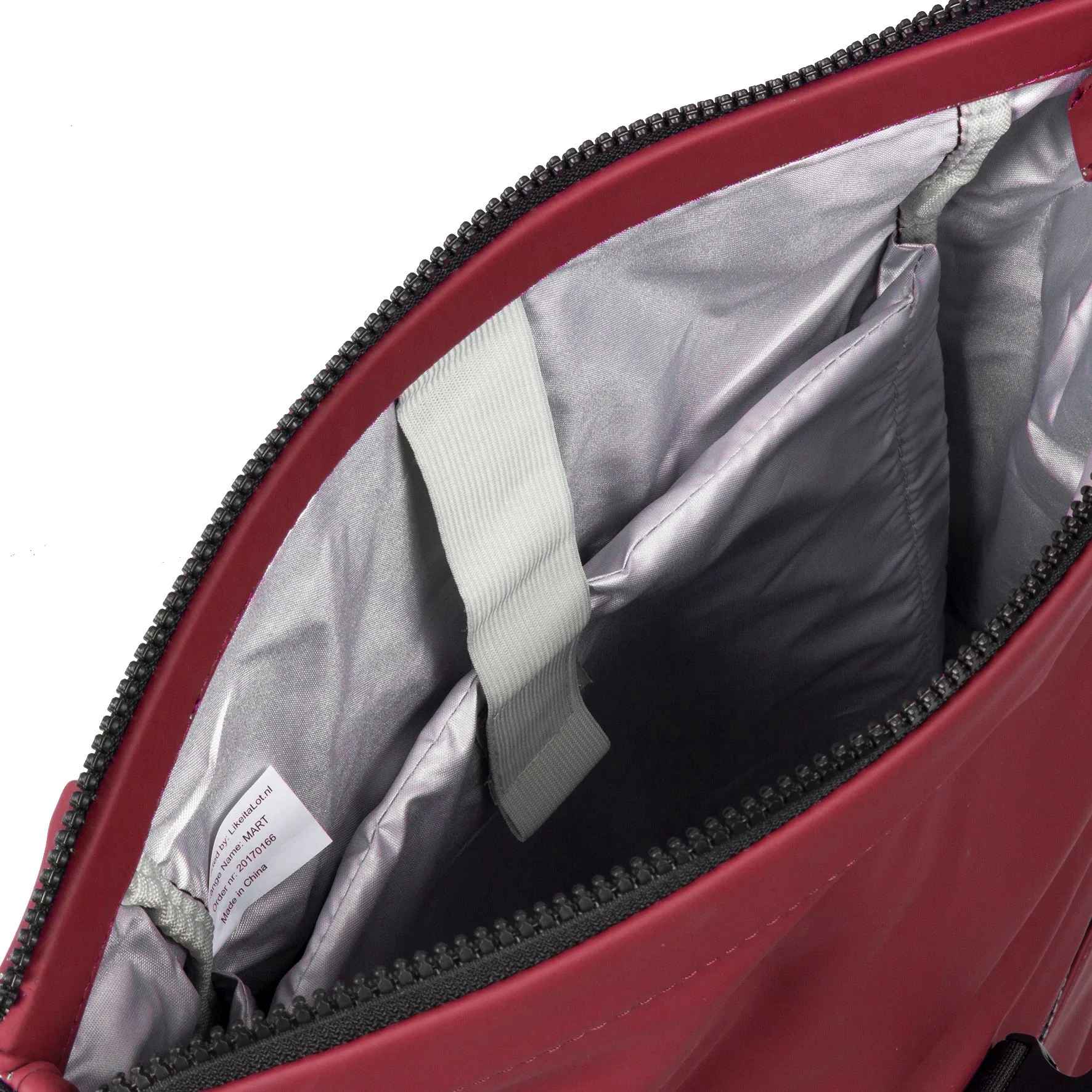 Open view of the New York Rolltop Rucksack - Burgundy by New Rebels Mart, featuring a grey interior, a white fabric loop, two padded compartments, a white tag with text, and a black zip along the top edge. Gate21.ee