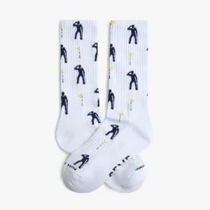 The Game - Athletic socks feature a white base with a repeating pattern of navy golfer silhouettes swinging clubs and small yellow flags. GENIUS and JLON are printed in black on the toes, perfectly capturing the playful spirit of Jimmy Lion athletic socks. Gate21.ee