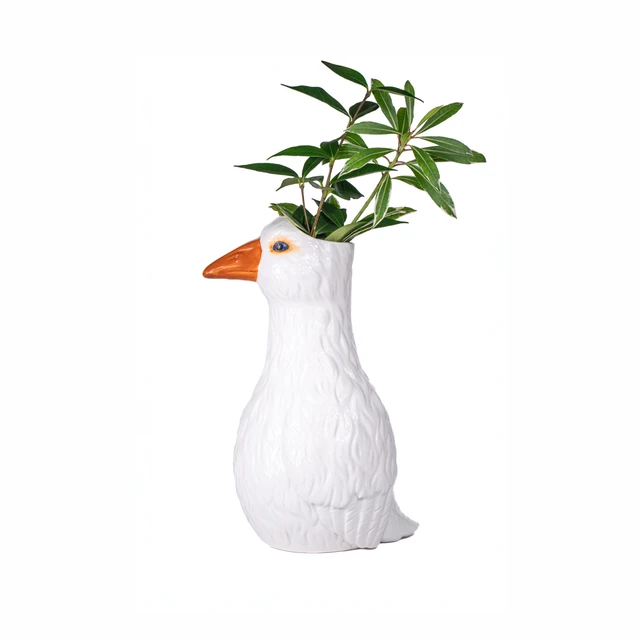 Goose - Vase featuring a white goose with an orange beak, designed to hold a green leafy plant that appears to grow from the top of the goose’s head, set against a white background. Gate21.ee