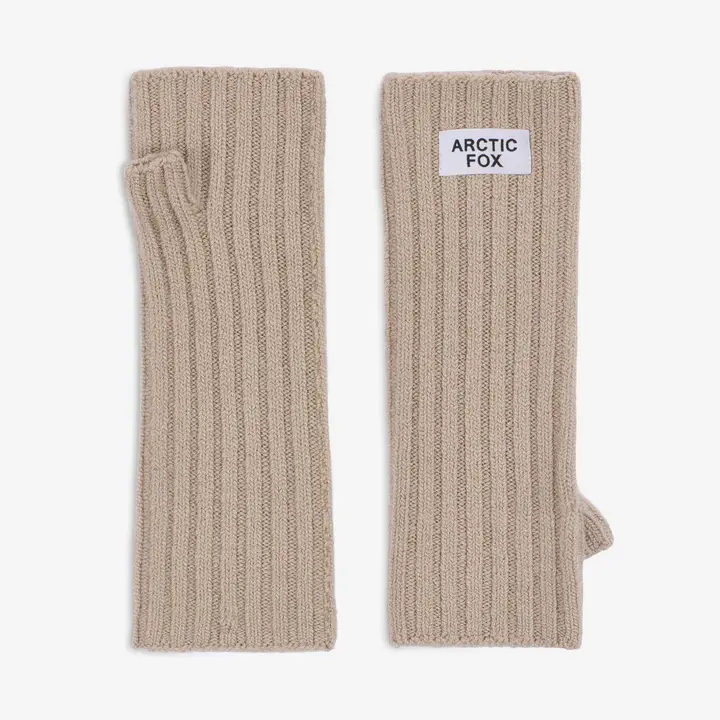 A pair of Merino Wool Fingerless Gloves in Soft Taupe are displayed side by side. One glove features a white rectangular patch labelled ARCTIC FOX near the top. The ribbed knit gloves have a thumb opening and are set against a plain background. Gate21.ee