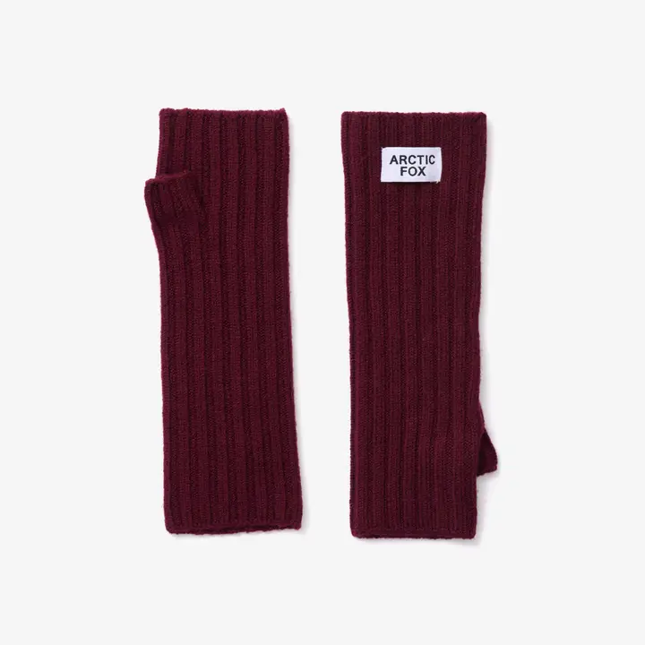 A pair of Merino Wool Fingerless Gloves in the Cherry Plum colour is displayed on a white background. These ribbed knit hand warmers are perfect for chilly days, and one glove features a white patch on the wrist with the text ARCTIC FOX. Gate21.ee