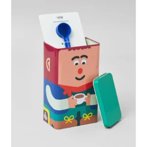 A rectangular Kitchen Storage / Coffee Tin - Lil’Guy, featuring a cartoon person holding a cup on the front—perfect for gifting to coffee lovers. Its green lid rests against the side, revealing a blue scoop and a white card inside. Set against a plain grey background. Gate21.ee