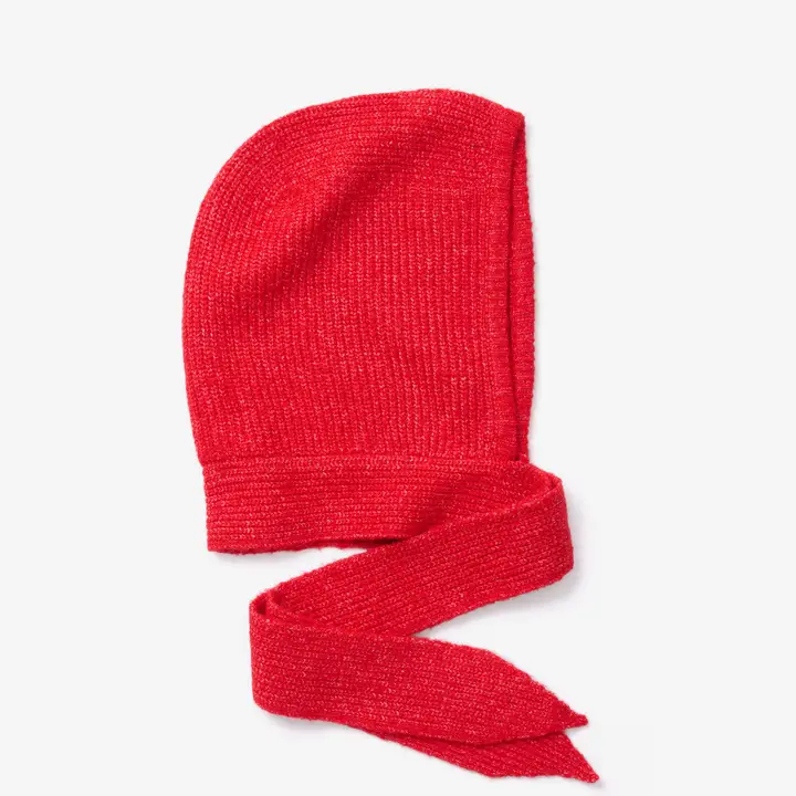 A red knitted bonnet, The Bonnet - Red - Recycled, is laid flat on a white background. The bonnet appears soft and textured, with long pointed ties—evoking the cosy warmth of Arctic Fox Reykjavik hand warmers. Gate21.ee