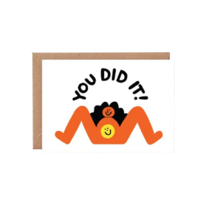 The “You Did It! - Greeting Card” features an abstract illustration of a person lying on their back with legs up and smiling, with the words “YOU DID IT!” displayed above. Set against a white background and paired with a partially visible brown envelope, this card is perfect for celebrating achievements. Gate21.ee